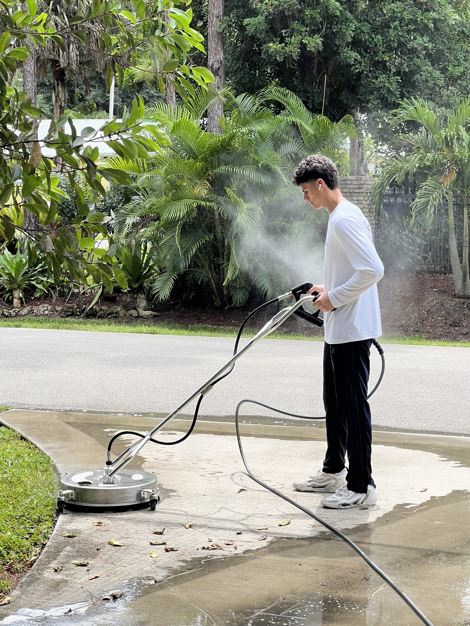 Leonardo pressure washing a driveway in North Naples